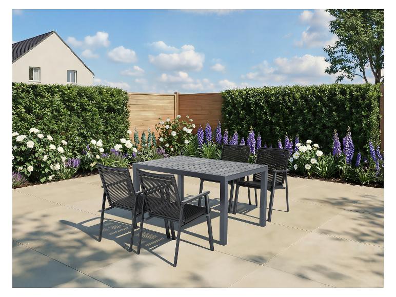 Tuinmeubelset met tafel en vier stoelen op een terras, omringd door groen.