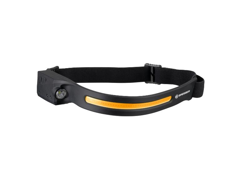 Een zwarte Bresser hoofdlamp met een oranje lichtstrip.