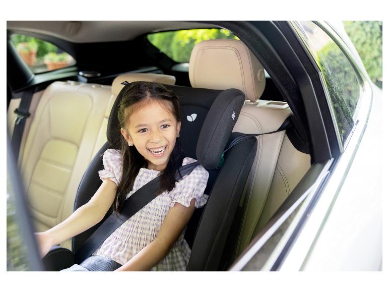 Lachend meisje in kinderzitje op de achterbank van een auto.