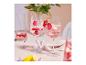 Twee wijnglazen met roze drank, frambozen en rode bessen, versierd met bloemmotieven.