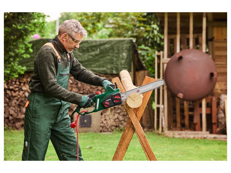 Een man gebruikt een Parkside kettingzaag om hout te zagen.