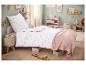 Kinderkamer met eenpersoonsbed met wit beddengoed met roze hartjes.