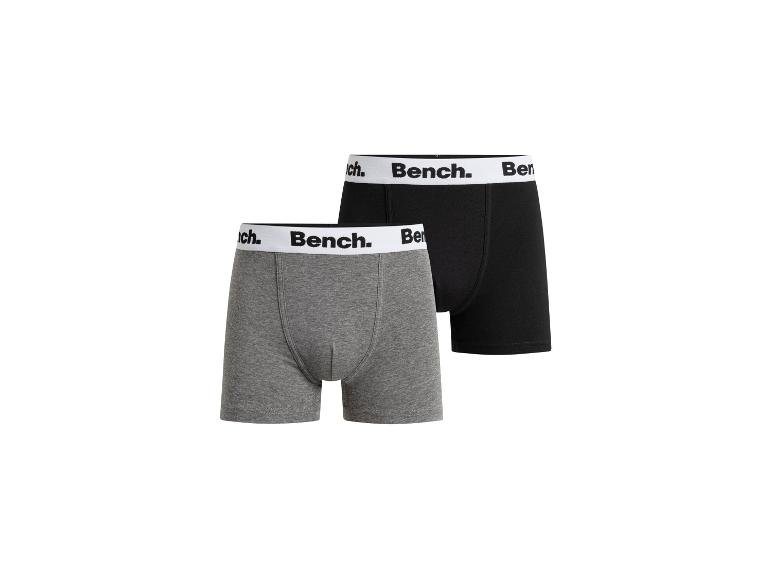 Twee Bench boxershorts, één grijs en één zwart, met wit Bench-logo op de tailleband.