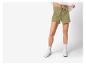 Vrouwelijke lichtgroene sport shorts en witte sneakers.