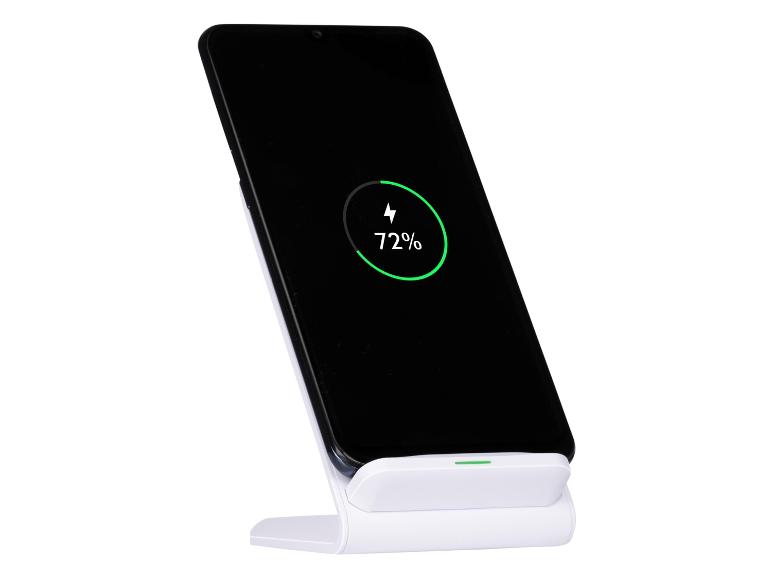Zwarte smartphone op een witte draadloze opladerstandaard