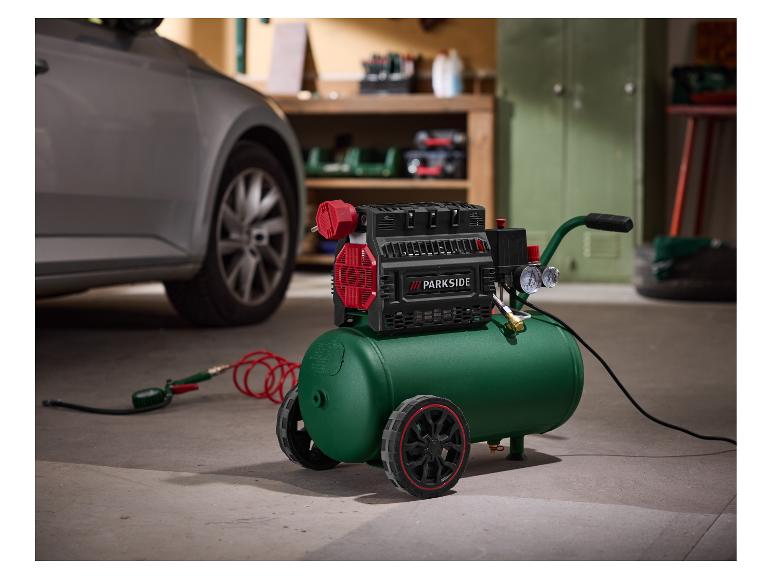Groene PARKSIDE luchtcompressor met wielen, slang en manometer in een garageomgeving.
