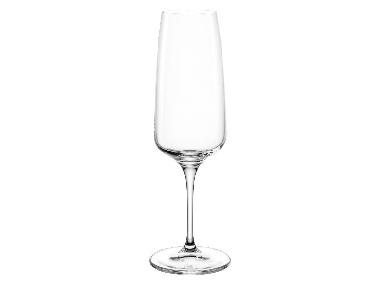 Leeg, transparant champagneglas met dunne steel op een witte achtergrond.