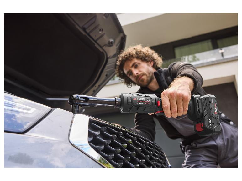 Een man gebruikt de PARKSIDE PERFORMANCE 20 V accu-ratelsleutel bij een automotor.
