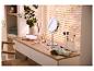 Kaptafel met LED-spiegel, make-upkwasten en cosmetica, met plant en jaloezieën op de achtergrond.