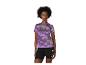 Vrouw in paars sportshirt met patroon en zwarte korte broek.