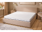 Gestoffeerd bed met matras en topper in een slaapkamer met natuurlijke tinten.