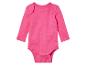 Een roze baby-romper met lange mouwen.