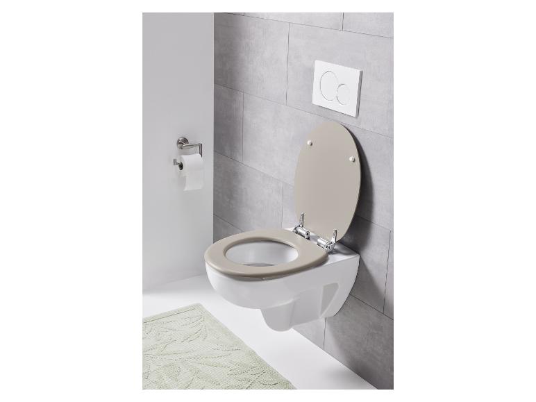 Een toilet met een beige toiletbril en een inbouwreservoir.