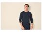 Man in donkerblauw shirt met lange mouwen en onderbroek glimlacht