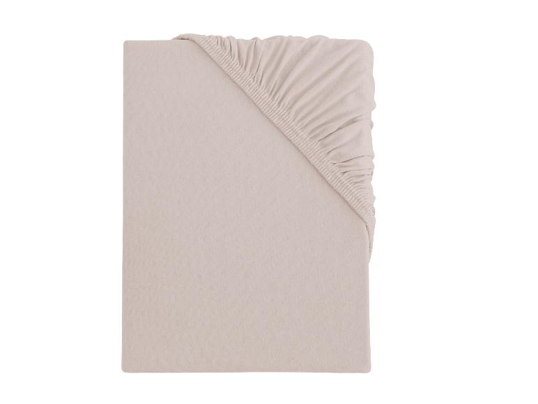 Opgevouwen lichtbeige hoeslaken met elastiek