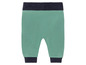 Groene broek met donkerblauwe boord.