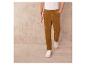 Man draagt een beige corduroy broek en witte sneakers.