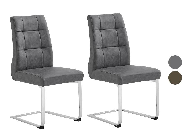 Twee donkergrijze designstoelen, met verchroomde metalen poten.