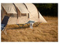 Een campingbed en een vouwstoel voor in de tent.