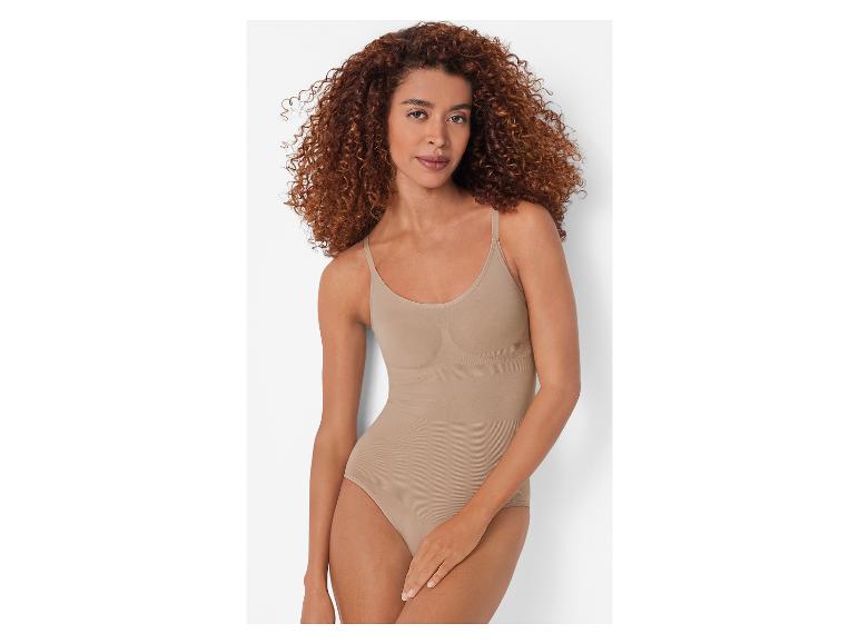 Een vrouw met krullend haar draagt een huidkleurige shapewear-body.
