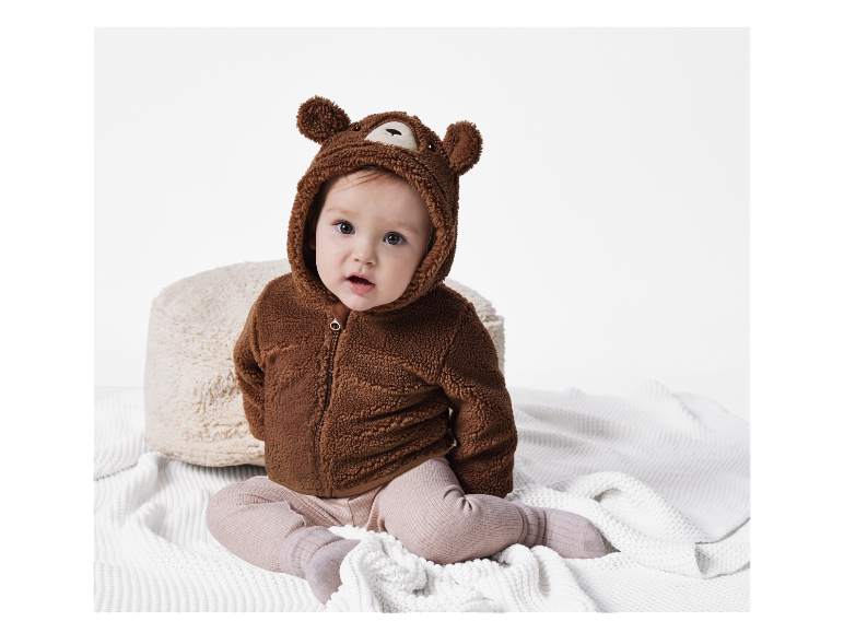 Schattig baby in een bruine teddyberen jumpsuit.