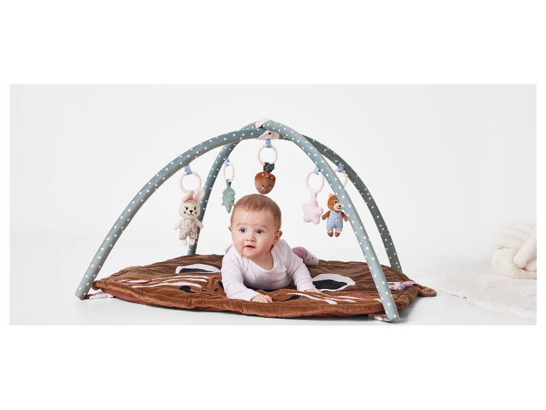 Baby liggend op een speelmat met kap.