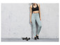 Een vrouw in sportkleding met leggings en dumbbells.