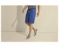 Man draagt blauwe shorts en grijze espadrilles.