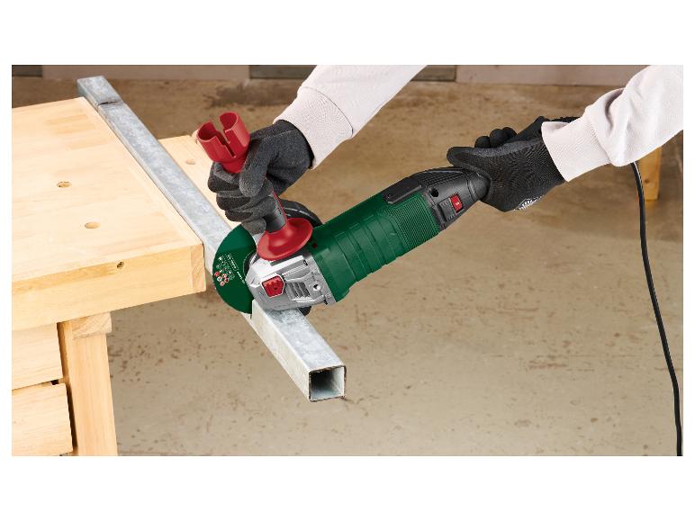 Een persoon snijdt een metalen pijp met een haakse slijper op een werkbank.