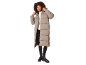 Vrouw in lange beige pufferjas, witte coltrui, zwarte broek en zwarte laarzen.