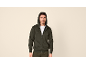 Man in donkergroene hoodie met rits, op een neutrale achtergrond.