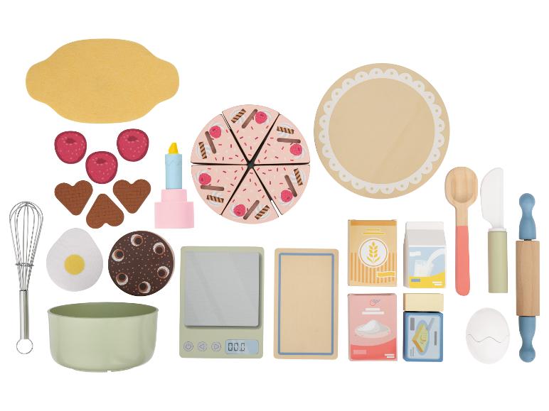 Bakset met taart, bessen, keukengerei en ingrediënten.