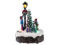 Verlichte kerstdecoratie met figuren van kinderen, een boom and een lantaarnpaal.