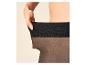 Vrouw trekt zwarte panty omhoog, toont de elasticiteit.