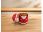 Kerstman-vormige koekjesdoos met koekjes op een houten tafel.