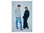 Man en vrouw in grijze en zwarte sweatshirts met 'STRENESSE BLUE' en jeans.