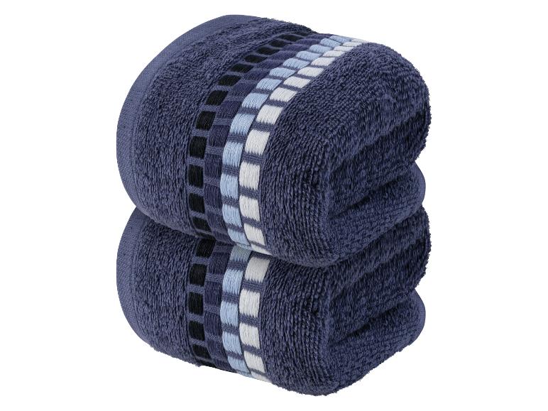 Twee donkerblauwe handdoeken met een geometrisch patroon.