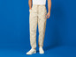 Beige broek met Lidl-print en witte sneakers.