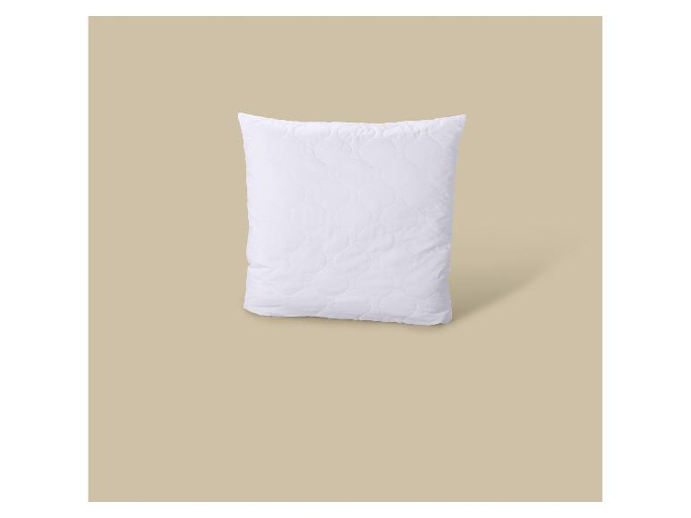 Wit gewatteerd kussen op een beige achtergrond