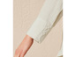 De mouw van een licht beige blouse met knopen.
