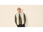 Man met beige muts, groen shirt met lange mouwen en lichtgrijze bodywarmer.