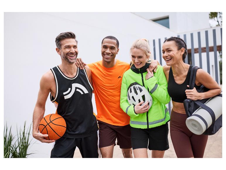 Vier vrienden in sportkleding lachen en dragen sportuitrusting.