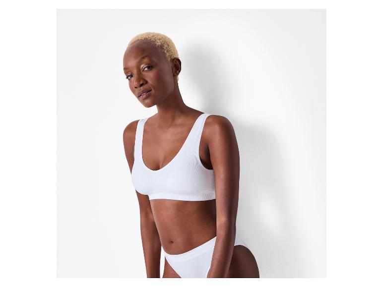 Vrouw met blond haar in witte naadloze sportbeha en slip.