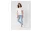 Vrouw in een wit T-shirt met tekstprint en lichtblauwe skinny jeans.