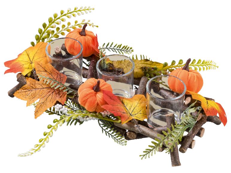 Herfstdecoratie met drie theelichthouders, pompoenen en bladeren