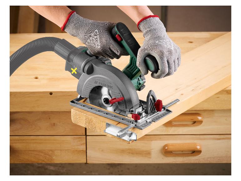 Handen met handschoenen gebruiken een PARKSIDE cirkelzaag om een houten plank te zagen.