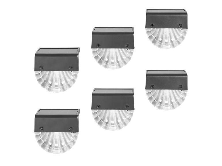 Zes solar buitenlampen met een donkere behuizing en een heldere, geribbelde diffuser.