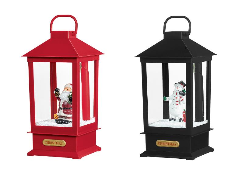 Twee kerstlantaarns, één rood met de Kerstman, één zwart met een sneeuwpop.