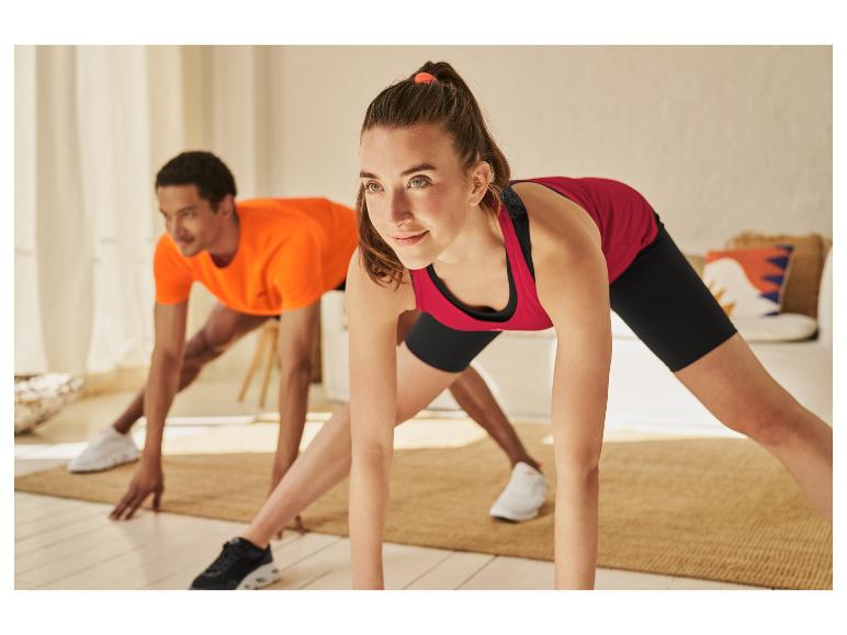 Een vrouw en een man doen yoga thuis.