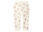 Crèmekleurige kinderjoggingbroek met roze regenboog- en hartpatronen.